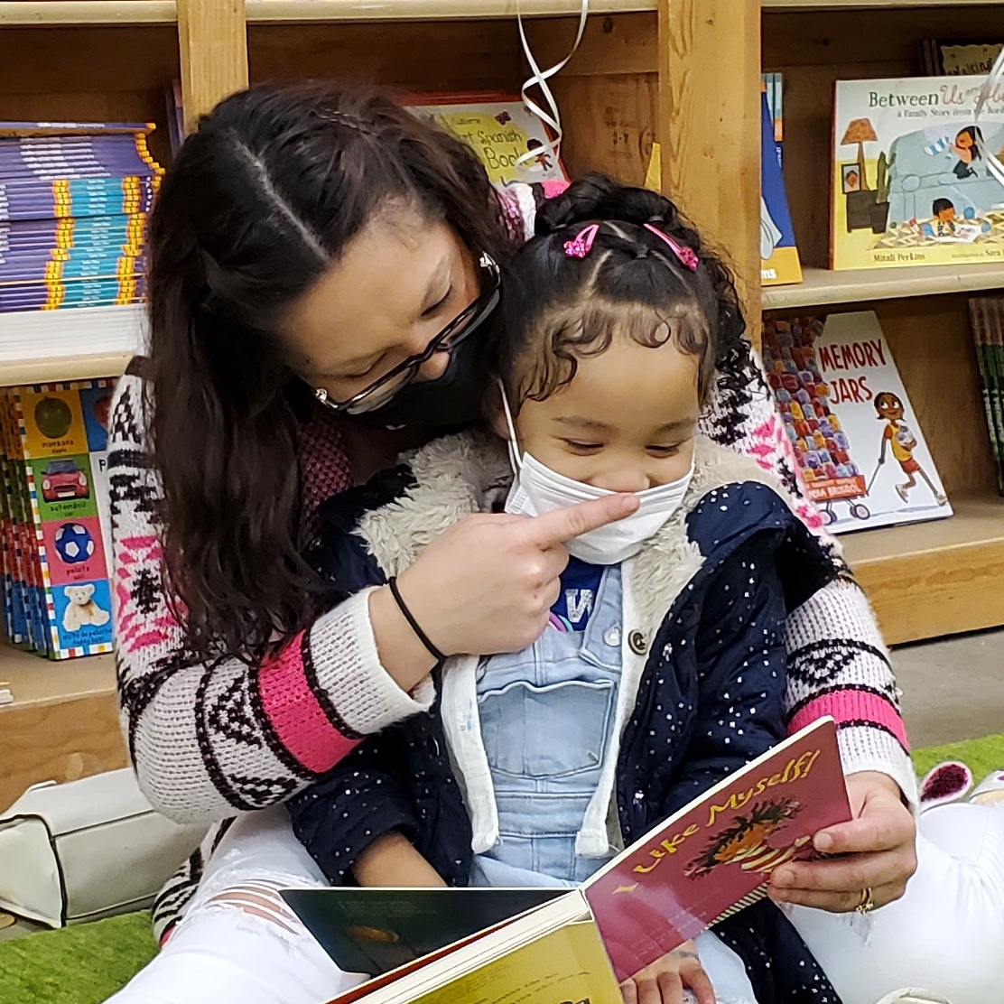 photo of an adult reading with a child